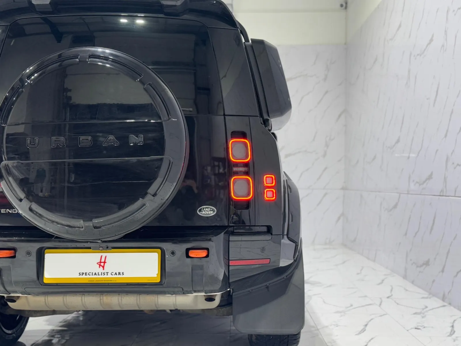 2023 Land Rover Defender 110 — Rear view showing the spare wheel cover and tail lights