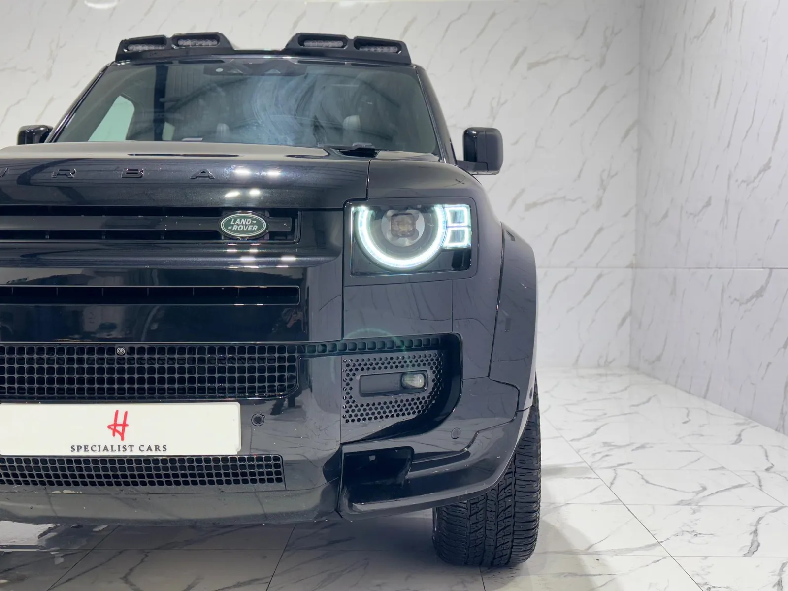 2023 Land Rover Defender 110 — Front of the car from low down, showing the grille and bumper