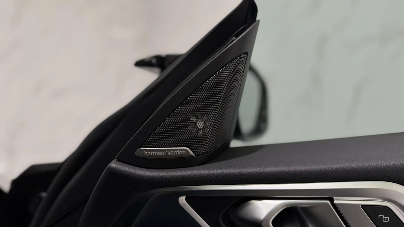 2023 BMW i4 — Close view of a speaker grille in the door mirror sail panel