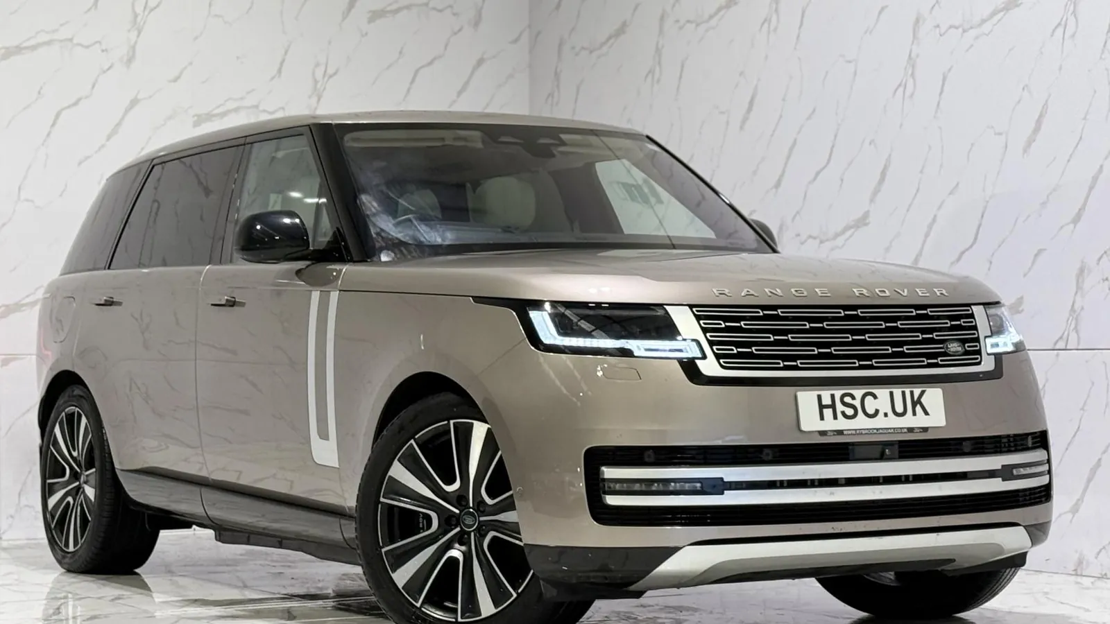 2023 Land Rover Range Rover — Front three-quarter view of the bronze Range Rover on the showroom floor