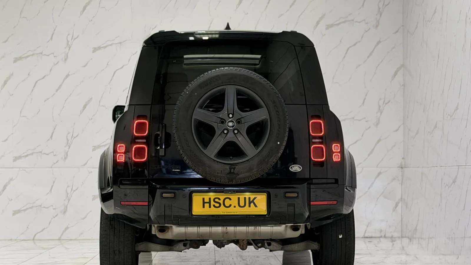 2021 Land Rover Defender 110 — Rear view showing the side-hinged door and mounted spare wheel
