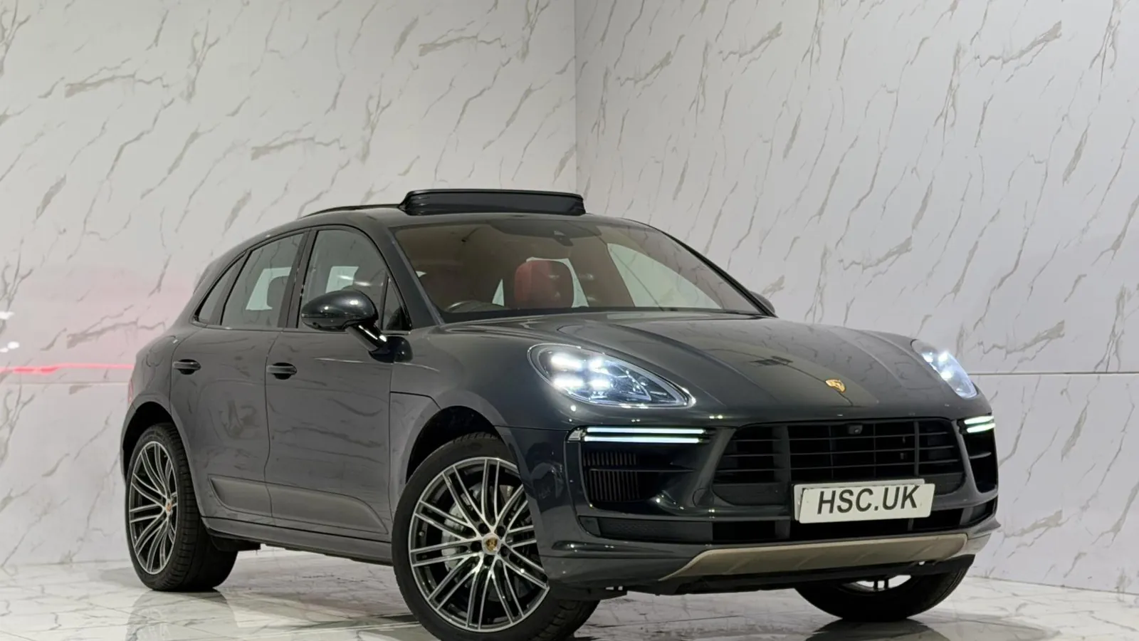 2019 Porsche Macan — Front three-quarter view of the grey Macan Turbo on the showroom floor