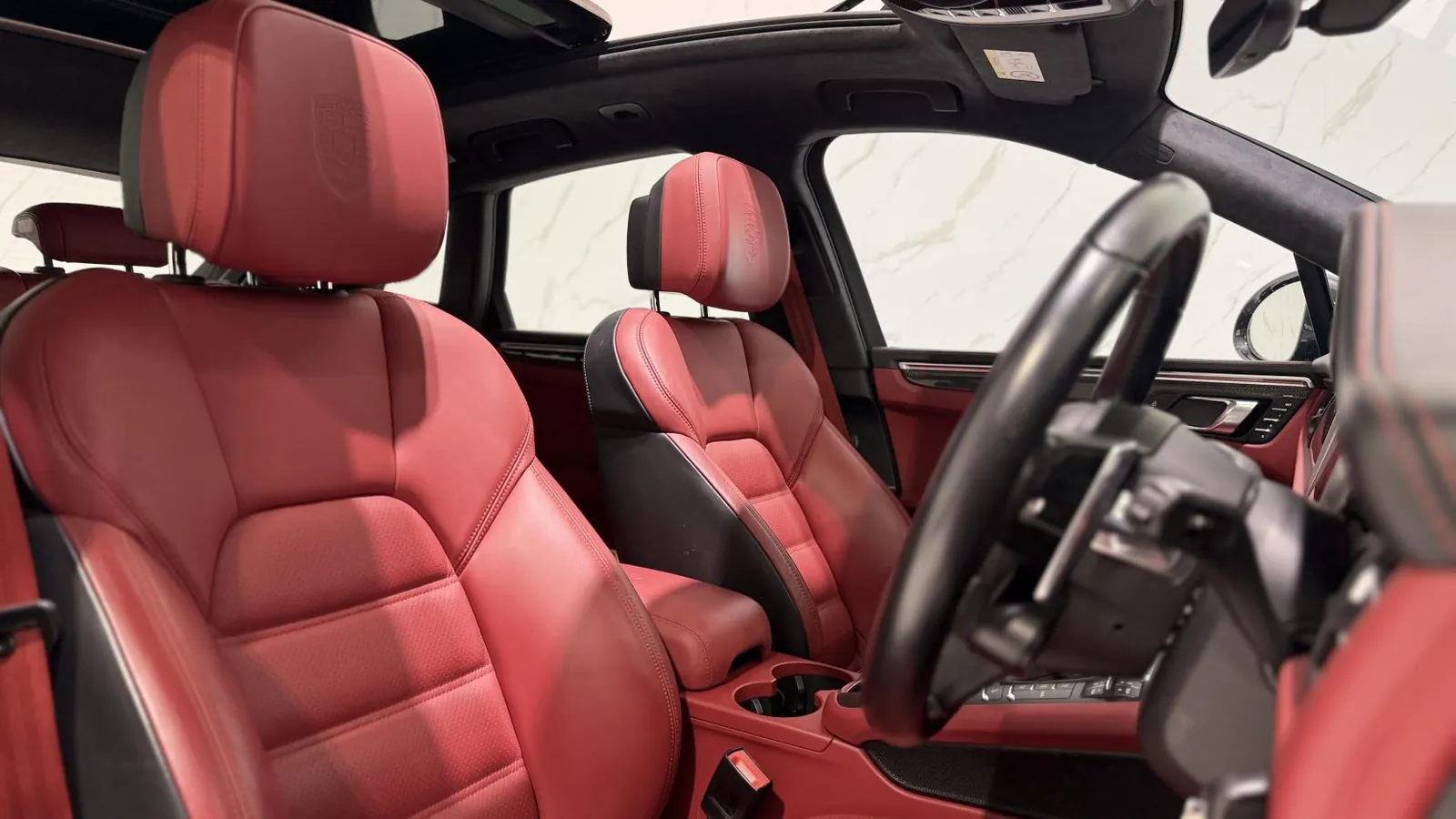 2019 Porsche Macan — Cabin looking forward across the red leather to the steering wheel