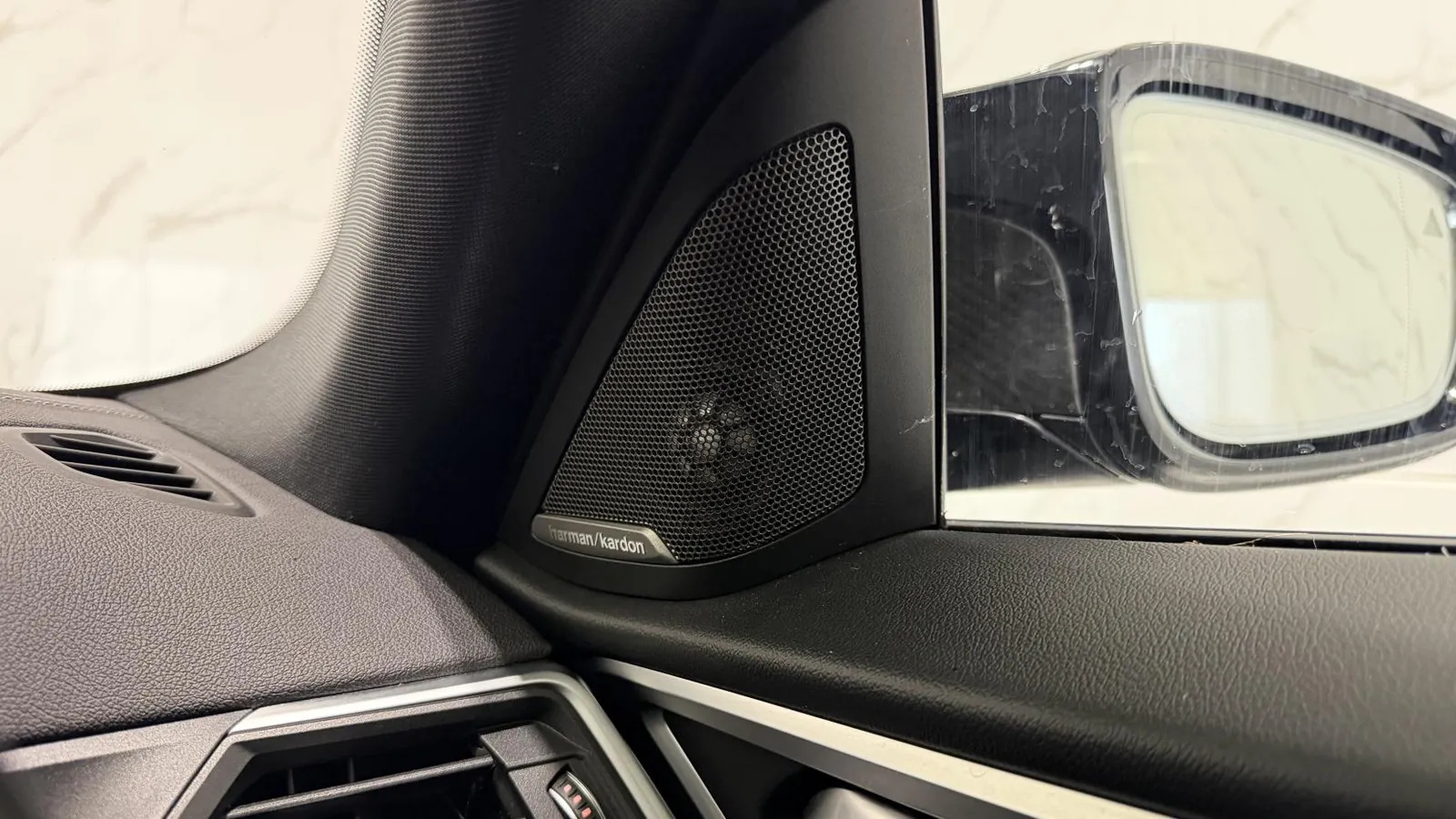 2022 BMW i4 — Close view of a speaker grille in the door mirror sail panel