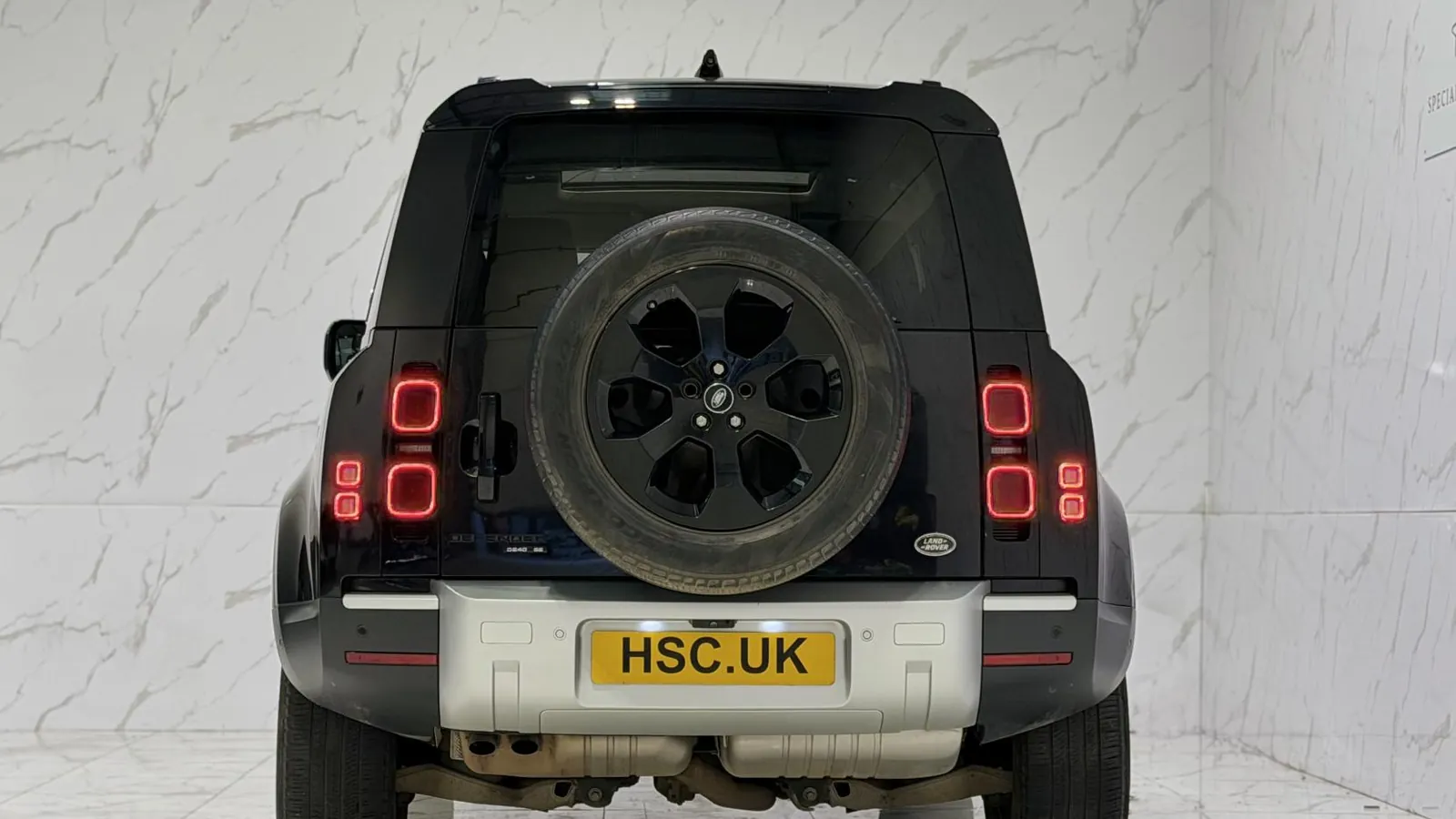 2020 Land Rover Defender 110 — Rear view showing the side-hinged door and mounted spare wheel